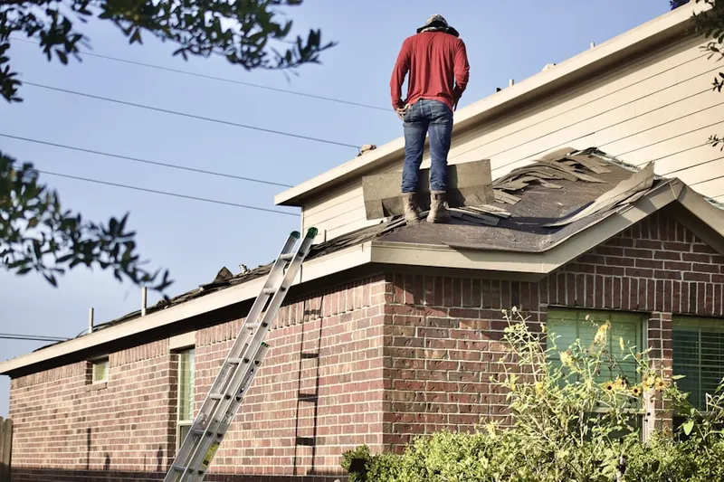 Professional roofer working on a residential roof in Tice